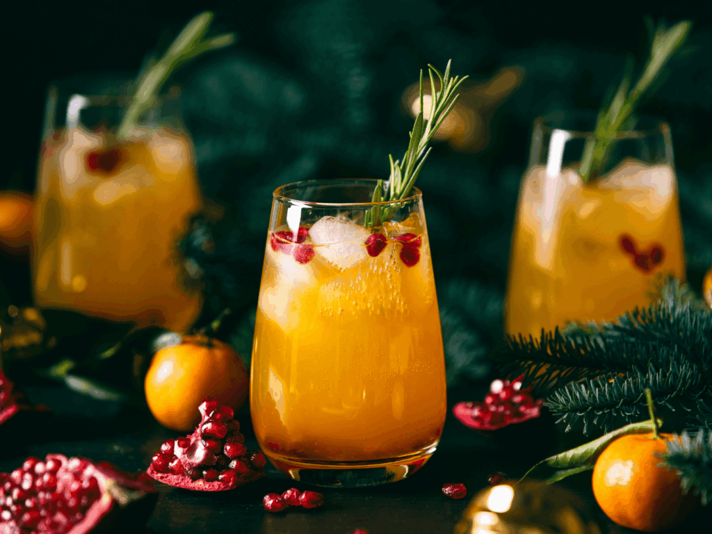 A close up of warm apple cider cocktail garnished with pine and cranberries
