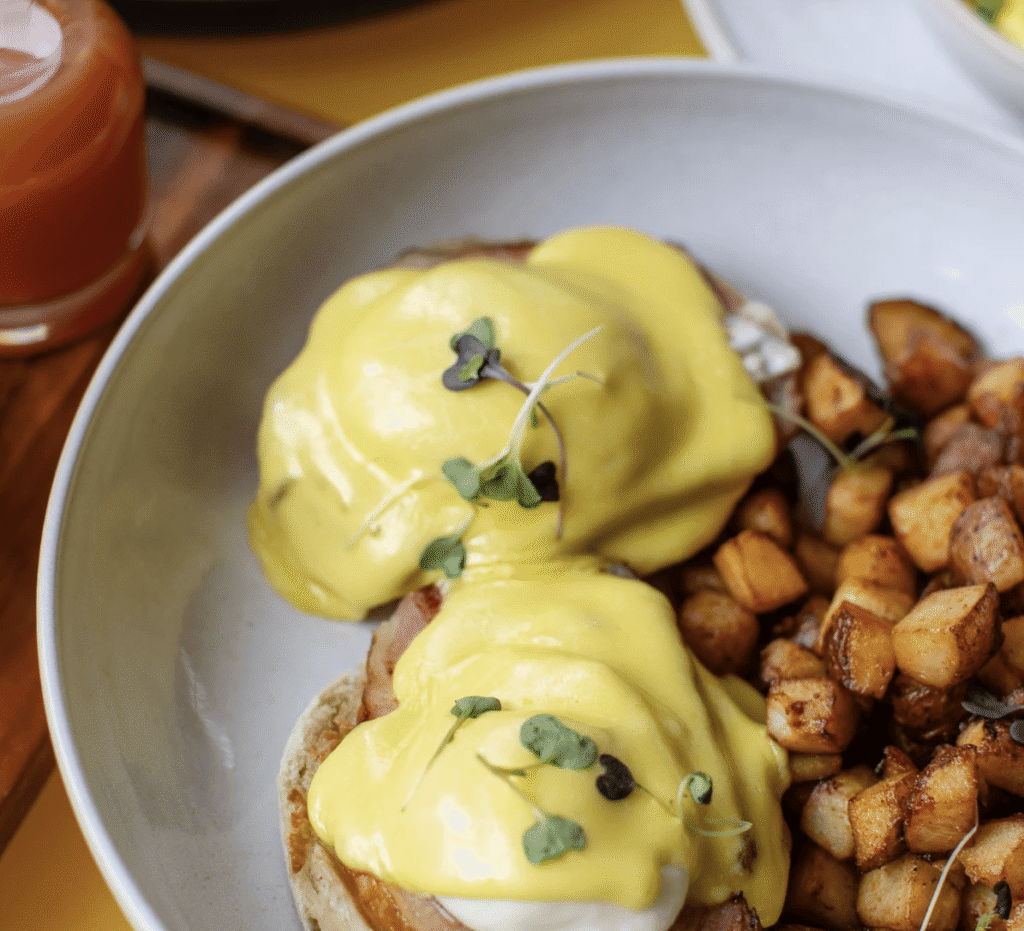 eggs benedict with a healthy amount of hollandaise sauce and topped with chives